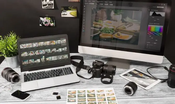 A laptop and camera on top of a desk.