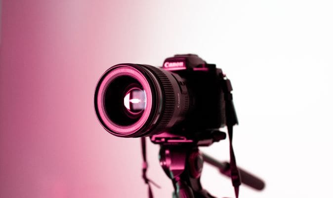 A camera is shown with pink lighting on it.